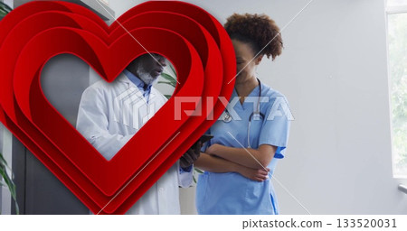 Reviewing tablet and stethoscope, doctor and nurse consulting in corridor, heart graphic overlay Reviewing tablet and stethoscope, doctor and nurse consulting in corridor, heart graphic overlay 133520031