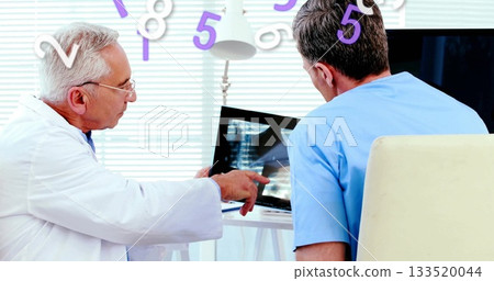 Pointing doctor in lab coat and colleague checking X-ray monitor at clinic, with floating numbers Pointing doctor in lab coat and colleague checking X-ray monitor at clinic, with floating numbers 133520044
