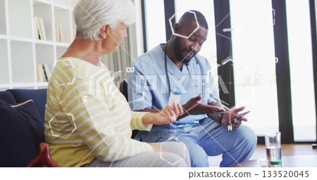 Discussing medication senior patient and nurse sitting on sofa at home, with pill bottle and tablet Discussing medication senior patient and nurse sitting on sofa at home, with pill bottle and tablet 133520045