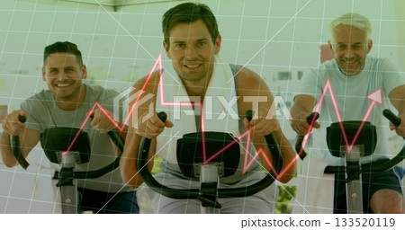 Pedaling three men riding exercise bikes in fitness studio, with white towel and red graph overlay Pedaling three men riding exercise bikes in fitness studio, with white towel and red graph overlay 133520119