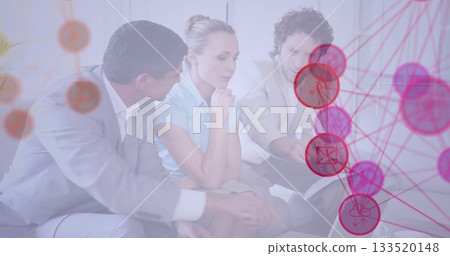 Collaborating team in formal wear around laptop on table in office lounge with network diagram Collaborating team in formal wear around laptop on table in office lounge with network diagram 133520148