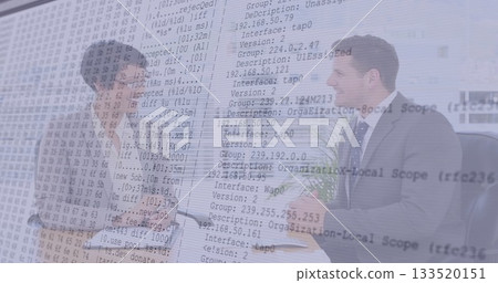 Shaking hands woman and man wearing gray suit at glass conference room desk, with code overlay Shaking hands woman and man wearing gray suit at glass conference room desk, with code overlay 133520151