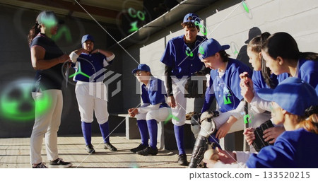 Gathering coach and softball team planning lineup in concrete-block dugout, with gloves and bat 133520215