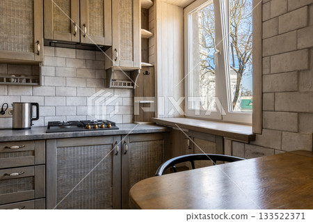 Bright Rustic Kitchen with Wooden Cabinets and Open Window 133522371