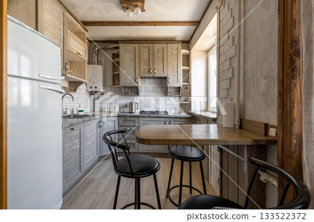 Cozy Rustic Kitchen Interior with Wooden Furniture and Breakfast Area 133522372