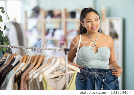 Young woman choosing jeans in clothing store 133523494