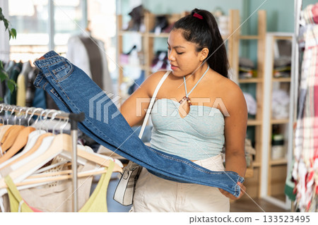 Girl at trading floor pick out and buying jeans trousers 133523495