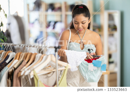 Young woman chooses panties in clothing store Young woman chooses panties in clothing store 133523663