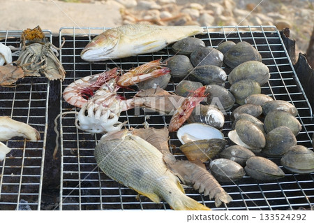 Grilled fish and shellfish on charcoal grill in Thailand. 133524292