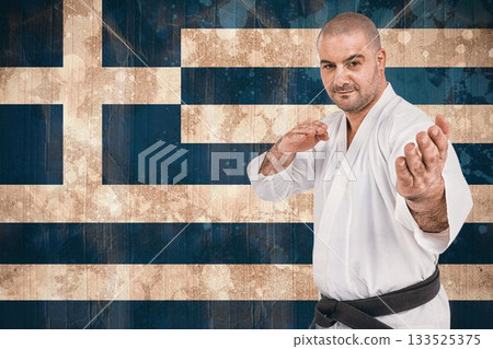 Portrait of martial artist practicing against Greek Flag 133525375