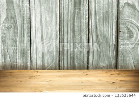 Rustic wooden tabletop is resting against weathered vertical wall panels in flat design, copy space 133525644