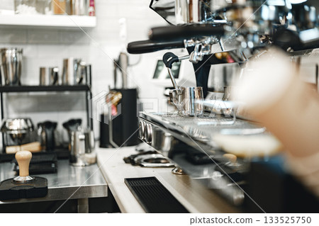 Coffee preparation station in a modern cafe with stainless steel equipment and tools 133525750