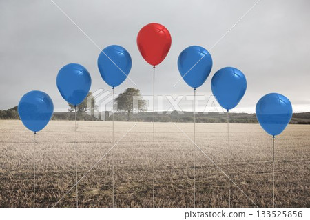 Harvested stubble field is showing flat design, with tethered red and blue balloons under grey sky Harvested stubble field is showing flat design, with tethered red and blue balloons under grey sky 133525856