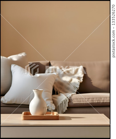 A cozy interior scene featuring a vase, glass, tray, pillows, blanket, and a sofa. 133526270