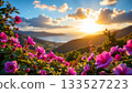 A serene landscape scene. It features a lush hillside blooming with vibrant flowers, against which a tranquil lake is nestled 133527223