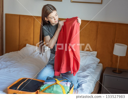 Woman packing clothes for travel trip preparing suitcase Woman packing clothes for travel trip preparing suitcase 133527983