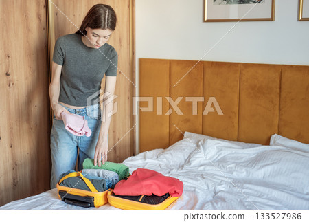 Young woman packing clothes for an upcoming trip 133527986