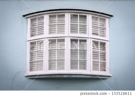 White Bay Window With Shutters On Light Blue Wall White Bay Window With Shutters On Light Blue Wall 133528611