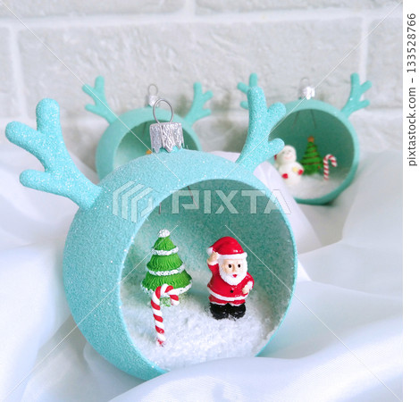 Christmas decorations in the shape of a ball with horns and small figures inside Christmas decorations in the shape of a ball with horns and small figures inside 133528766