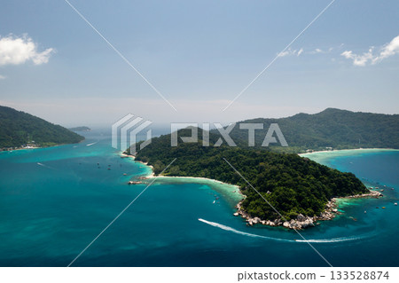 Stunning bird's-eye view of a tropical island with lush greenery and clear waters on a sunny day in the Perhentian Islands. Malaysia Stunning bird's-eye view of a tropical island with lush greenery and clear waters on a sunny day in the Perhentian Islands. Malaysia 133528874
