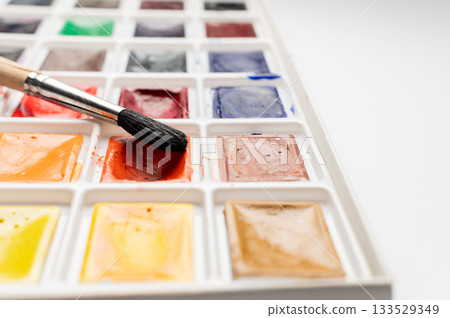 Watercolor paint with brush and paper. Close-up of a watercolor palette and brush, ready for painting, perfect for art, craft, and DIY projects Watercolor paint with brush and paper. Close-up of a watercolor palette and brush, ready for painting, perfect for art, craft, and DIY projects 133529349