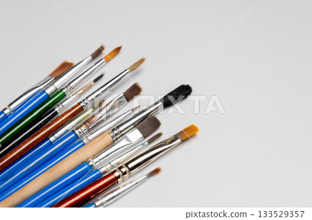 collection of art brushes of different sizes displayed on a white table. Overhead horizontal photo. Craft hobby background. Recomforting, destressing hobby, art therapy collection of art brushes of different sizes displayed on a white table. Overhead horizontal photo. Craft hobby background. Recomforting, destressing hobby, art therapy 133529357