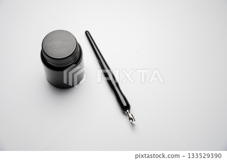 fountain pen with a bottle of ink on a white table. Stylish fountain pen on a white background. Stationery. Poetic ideas 133529390