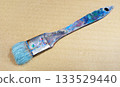 Close-up of art tools lined up with well-used paintbrushes 34 133529440