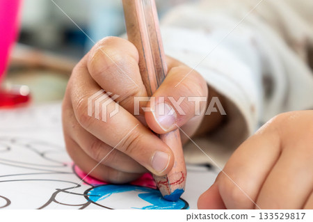 Child having fun with an authentic leisure activity, fine motor skills development 133529817