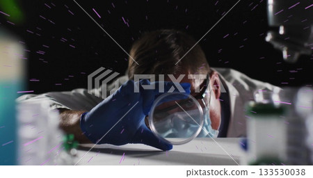 Leaning male scientist examining petri dish at white laboratory bench, with dynamic purple backdrop Leaning male scientist examining petri dish at white laboratory bench, with dynamic purple backdrop 133530038