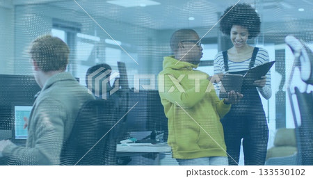 Discussing project team members gathering behind dotted glass in open-plan office with black binder 133530102