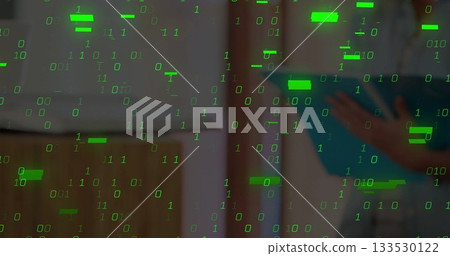 Cascading green binary digits overlaying blurred office shelving, with person holding blue folder 133530122