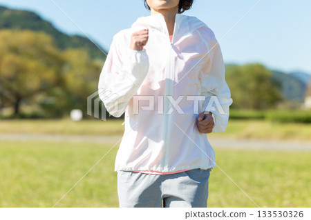 Middle-aged woman running outdoors Middle-aged woman running outdoors 133530326