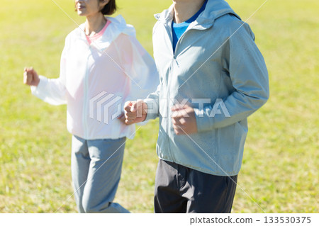 A middle-aged couple running outdoors 133530375