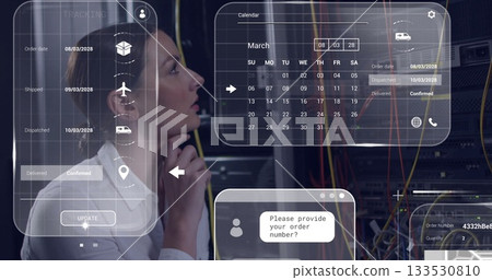 Analyzing white-shirted woman tracking UI panels in server room with racks and cables, copy space 133530810