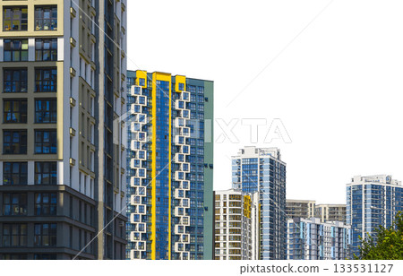 Contemporary residential high-rise buildings with glass facades and vivid yellow accents stand 133531127