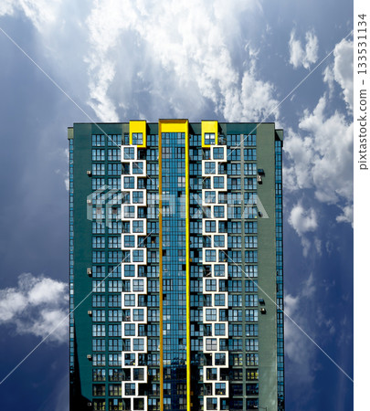 Modern residential high-rise with striking yellow vertical accents and symmetrical geometric design, 133531134