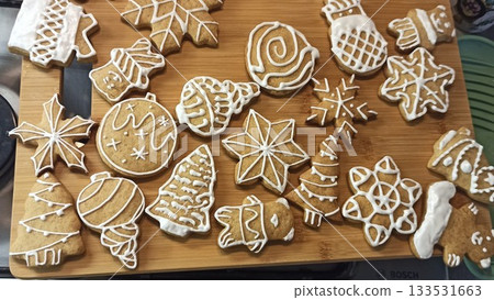 Christmas cookies decorated with white icing arranged on a wooden board. this image conveys holiday spirit, festive baking and cozy winter celebration Christmas cookies decorated with white icing arranged on a wooden board. this image conveys holiday spirit, festive baking and cozy winter celebration 133531663