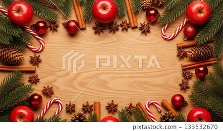 Christmas frame on a light wooden background surrounded by apples, spices and fir branches Christmas frame on a light wooden background surrounded by apples, spices and fir branches 133532670