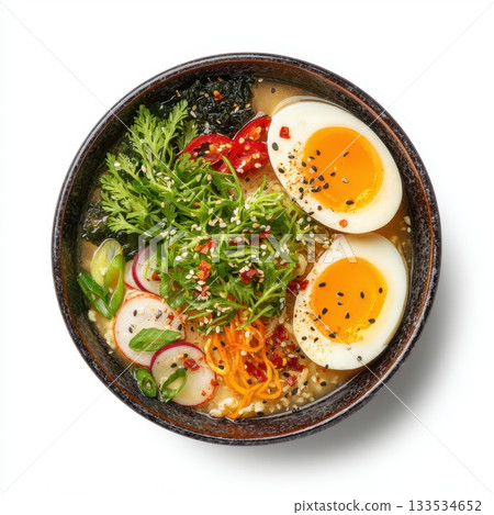 A delicious bowl of Japanese ramen soup with soft boiled eggs fresh greens radish and shredded carrots 133534652