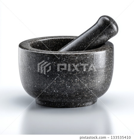 Dark speckled granite mortar and pestle set against a clean white background 133535410