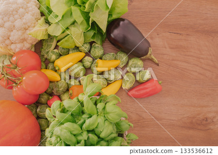 Top view of vibrant vegetables, herbs, and basket on a wooden table Top view of vibrant vegetables, herbs, and basket on a wooden table 133536612