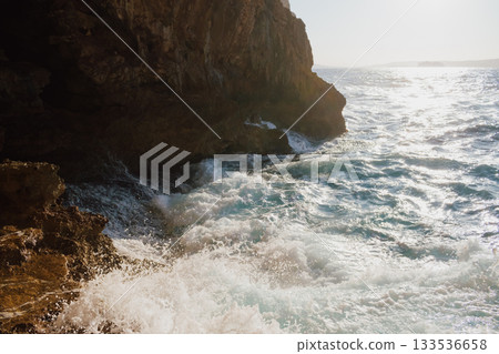 View from a cave to the sea on sunny day in summer. Mediterranean beauty landscape. Waves crashing on a rocky beach 133536658