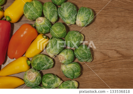 Colorful combination of brussel sprouts and bell peppers on a wood background 133536818