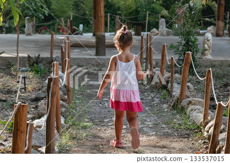 Little girl walking to an outdoor stretching class in Asian-inspired setting Little girl walking to an outdoor stretching class in Asian-inspired setting 133537015