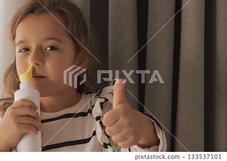 Happy demonstration: using a nasal spray and giving a thumbs up sign Happy demonstration: using a nasal spray and giving a thumbs up sign 133537101