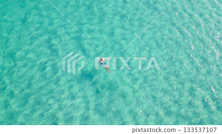 Young man swimming with mask in crystal clear turquoise sea water. Young man swimming with mask in crystal clear turquoise sea water. 133537107