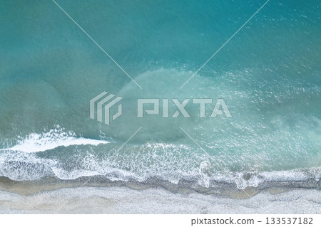 Drone view of a beach and foamy ocean waves, perfect background Drone view of a beach and foamy ocean waves, perfect background 133537182