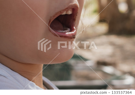Close-up of a smiling face with chocolate ice cream smeared around the mouth Close-up of a smiling face with chocolate ice cream smeared around the mouth 133537364