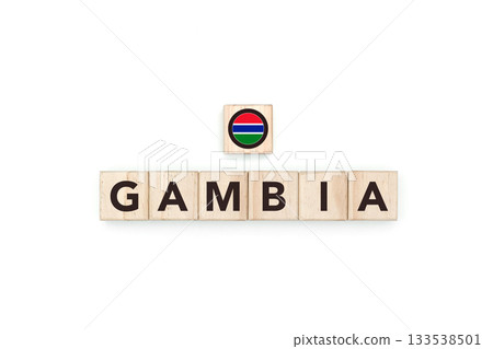 Wooden blocks bearing the name and flag of Gambia. Gambian and African Culture, national identity, travel, and geography in a copy space design. Wooden blocks bearing the name and flag of Gambia. Gambian and African Culture, national identity, travel, and geography in a copy space design. 133538501
